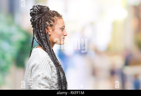 Giovani capelli intrecciati African American Girl indossa un maglione su sfondo isolato guardando al lato, profilo relax posano con faccia naturale con fiduciosa Foto Stock