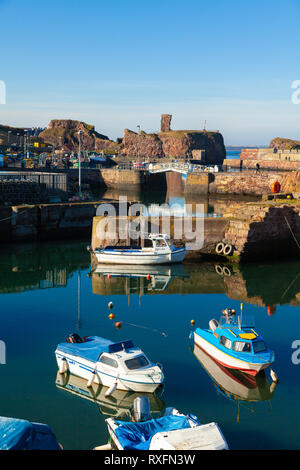 Imbarcazioni da diporto ormeggiata in Old Dunbar Harbour con Dunbar Castle in background. Dunbar, East Lothian, Scozia Foto Stock