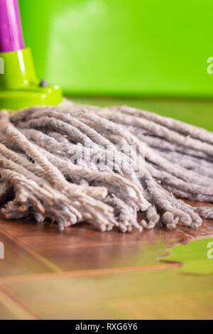 Corda mop sulle piastrelle del pavimento e una pozza d'acqua. Pulizia della casa e il concetto di pulizia Foto Stock