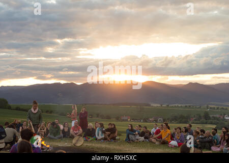 Drienok, Slovacchia - Giugno 2017: gruppo di persone sedute intorno al falò godersi il tramonto in Drienok, Slovacchia Foto Stock