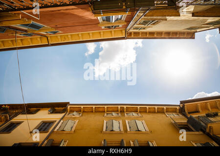 Il punto di vista di un vicolo colorato con molte finestre in una giornata di sole con nuvole. Foto Stock