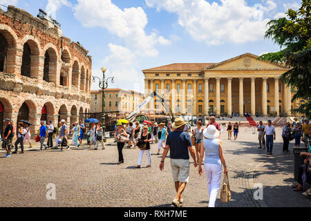 VERONA Italia - 25 giugno 2016: Immagine di Piazza Bra con turisti e una vista frontale del Municipio con l'Arena di Verona sul lato sinistro in un sunn Foto Stock