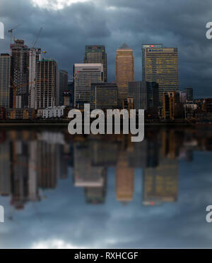 I blocchi a torre del quartiere finanziario nelle Docklands di Londra si riflette nel fiume Tamigi al crepuscolo Foto Stock