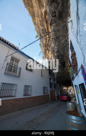 Auto incrocio sotto abitazioni costruite nella roccia a Setenil de las Bodegas, Cadiz, Spagna Foto Stock