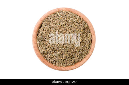 I semi di anice in ciotola di legno isolato su sfondo bianco. Spezie e ingredienti alimentari. Foto Stock