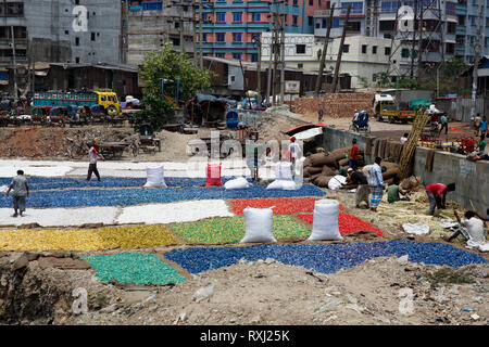 Plastica riciclata essiccamento chips sulla banca del fiume Buriganga a Dhaka, nel Bangladesh. Foto Stock