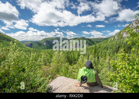 Escursionista singolo uomo e di appoggio alla ricerca di una bella vista della montagna in Les Grands-Jardins National Park, provincia del Québec in Canada Foto Stock