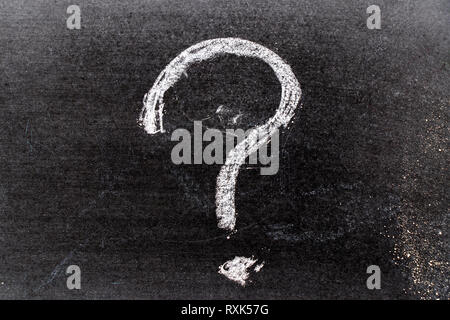 Colore bianco chak del disegno a mano nel punto interrogativo forma su sfondo blackboard Foto Stock