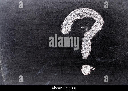 Colore bianco chak del disegno a mano nel punto interrogativo forma su sfondo blackboard Foto Stock
