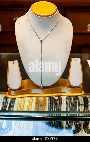 Un oro bianco perla collana, pendente da un collo stampo, sul display per la vendita in uno Hyderabad i molti negozi di gioielli. Hyderabad, Telangana, India. Foto Stock