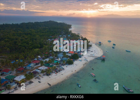 Sunrise a isola tropicale con villaggio vicino al fronte spiaggia. Isola di Mantanani Sabah Borneo Malese. Foto Stock