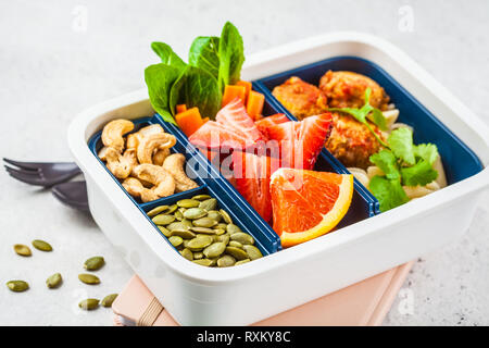 Cibo sano e scatola di pranzo. Pasto sano prep contenitori con polpette di fagioli, pasta, verdure, frutti di bosco, semi e noci in un contenitore su un backgr bianco Foto Stock