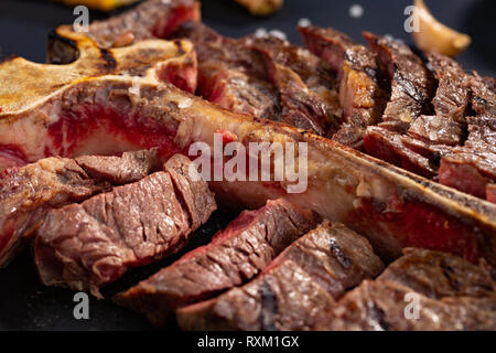 Osteria bistecca alla griglia di tranciato su un pezzo di legno. Scheda di stile rustico, vista dall'alto Foto Stock