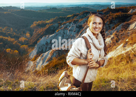 Sorridente assolo sani tourist donna in escursionismo marcia con borsa su estate toscana trekking cercando da parte. Foto Stock