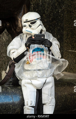 Planet Hollywood attore in Star Wars stormtrooper costumi utilizzando il telefono cellulare durante una pausa di interagire con il pubblico per promuovere il luogo Foto Stock