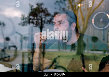 L'uomo affamato che mangia un dolce Foto Stock