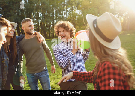 Amici giocare nel parco con la palla in estate. Foto Stock