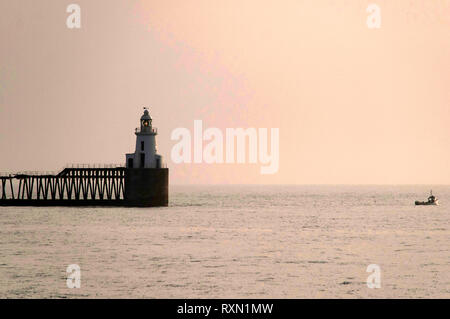 Sunrise a Blyth pier con la barca da pesca, Northumberland Foto Stock