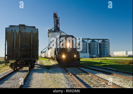 Locomotiva con Rail Hopper vetture a un entroterra terminale di grano, vicino a Winnipeg, Manitoba, Canada Foto Stock