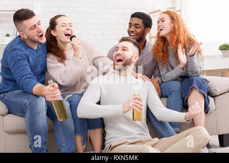 Gli amici di cantare karaoke, avente parte a casa Foto Stock