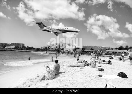 St Maarten, il Regno dei Paesi Bassi - Febbraio 13, 2016: spiaggia folle osservare bassa volare aerei lo sbarco nei pressi di Maho Beach sull'isola di St Maarten nei Caraibi Foto Stock