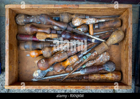 Una vecchia scatola di cacciaviti scartato al di fuori di un antico bric a brac shop Foto Stock