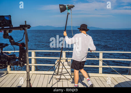 Adesivo telato o il capo elettricista in un moto-immagini televisive o unità di produzione impostare le luci e la luce stand su un germoglio commerciale Foto Stock