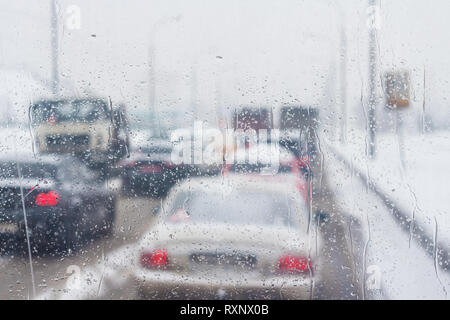 Le gocce di pioggia sulla vettura di vetro con una vista del traffico Foto Stock