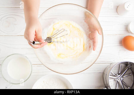 I bambini le piccole mani battete la pasta per frittelle cucina in cucina Foto Stock