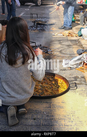 Bambini paella di cottura sulla strada a Valencia durante il Fallas Festival, Valencia, Spagna Foto Stock