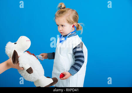 Ragazzo giocare vet medico con toy pecore madri in mano Foto Stock