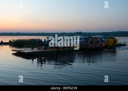 Dawn colpo di traghetto trasporto veicoli e persone attraverso Victoria fiume Nilo a Paraa in Murchison Falls National Park, Nord Uganda, Africa orientale Foto Stock