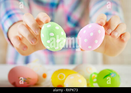 Felice Pasqua. Congratulazioni sfondo pasqua. Il bambino tiene le uova di Pasqua in mano. Messa a fuoco selettiva. Foto Stock