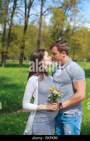 Godendo della gravidanza insieme.la famiglia insieme in estate park. La donna è in stato di gravidanza Foto Stock