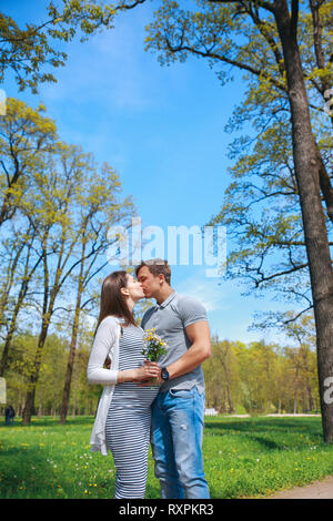 Godendo della gravidanza insieme.la famiglia insieme in estate park. La donna è in stato di gravidanza Foto Stock