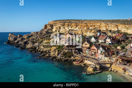 Bella vista sulla home di Popeye. Villaggio con molte case colorate in stile fumetto. Situato nella Baia di ancoraggio in Malta. Foto Stock