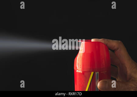 Mano azienda mosquito spray. Uomo, utilizzando spray di zanzara dalla bottiglia. Foto Stock