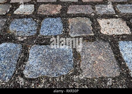 Vista ravvicinata della prospettiva diversa sul terreno in ciottoli di superfici prese sulla Germania settentrionale strade Foto Stock