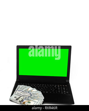 Colpo verticale di laptop o notebook con una diffusa del dollaro di denaro contante isolato su sfondo bianco con schermo verde modello di display mock up Foto Stock