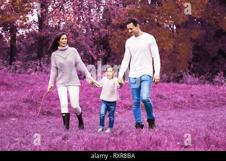 Famiglia passeggiate nei boschi con rosa colore viola Foto Stock