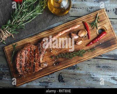 Agnello alla griglia costolette di vitello lombata su un tagliere, spezie , braciole Foto Stock