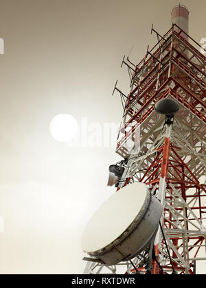 Torre di comunicazione con diversi tipi di antenne in un giorno di nebbia Foto Stock