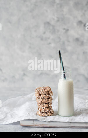 Pila di pane appena sfornato tahini biscotti con scaglie di cioccolato con una bottiglia di latte Foto Stock