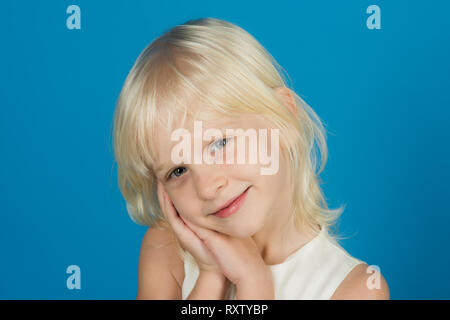 Closeup ritratto di un divertente bambina. Bambini in blue studio. Foto Stock