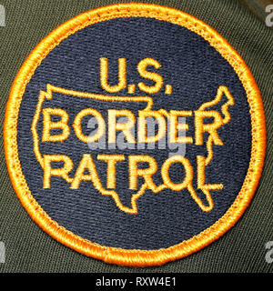 Badge della United States Border Patrol che mostra l'insegna circolare ufficiale a forma di scudo della USBP, con la scritta dorata "U.S. Border Patrol" e un contorno stilizzato della mappa degli Stati Uniti continentali in giallo su un terreno blu marino, utilizzato dagli agenti dell'agenzia federale delle forze dell'ordine responsabili della sicurezza delle frontiere. Fotografia di un distintivo ufficiale della polizia di frontiera Foto Stock