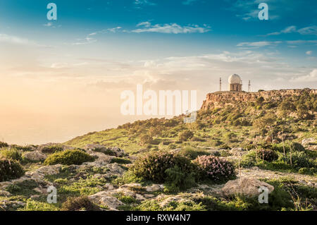 Dingli Cliffs, Malta: strada panoramica con una vista romantica su Dingli Cliffs e aviazione il radar al tramonto Foto Stock