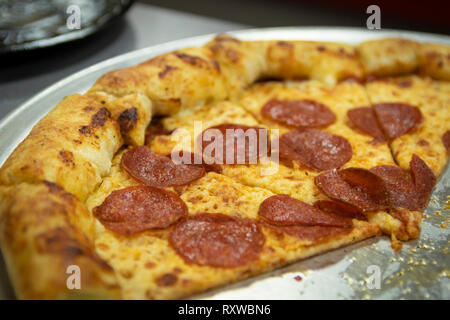 Fette di unto American salsiccia per pizza pizza in un ristorante pizza teglia. Foto Stock