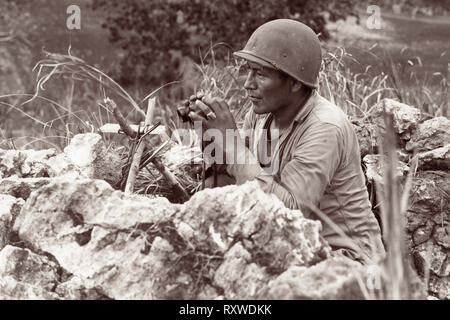 Indiano Navajo-codice Pfc parlante di Carl Gorman di Chinle Arizona, manning un posto di osservazione sulla cima di una collina che domina la città di Garapan, mentre gli Stati Uniti Marines sono state consolidando le proprie posizioni sull'isola di Saipan, Marianas il 27 giugno 1944 Durante la battaglia di Saipan. Foto Stock