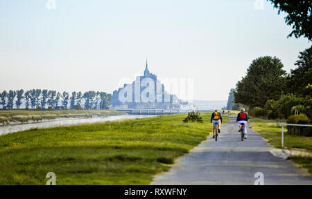 Le Mont Saint Michel: i ciclisti lungo il fiume Couesnon Foto Stock