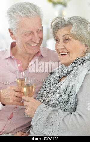 Ritratto di Coppia matura bere champagne a casa, close up Foto Stock